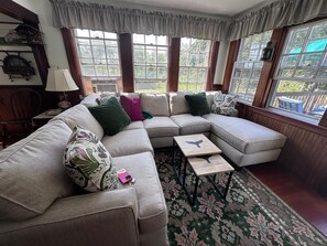 A sectional sofa with multiple cushions, a small side table, and a patterned rug. - North Chatham Beachwalk -Spacious 6 bedroom walk to beach sprawling private yard (Chatham)