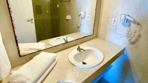 A bathroom with a sink, mirror, towel, and a phone mounted on the wall. - Mother Africa Apartment – ​​5 minutes from Primeira Praia (First Beach) (Morro de São Paulo)