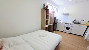 Makuuhuoneessa on sänky, puinen vaatekaappi, pesukone ja pieni keittokomero.