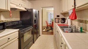 Eine kleine Küche mit Herd, Backofen, Kühlschrank und Spüle.