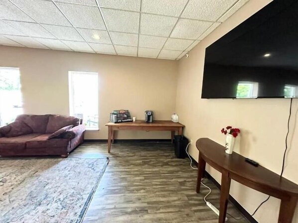 A living room with a sofa, a coffee table, a TV mounted on the wall, and a window. - Kiteville Phoenixville (Phoenixville)