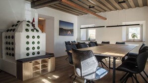 Une salle de réunion moderne, dotée d’une grande table en bois, de chaises noires et d’une décoration murale originale représentant un gnome et des cercles verts.