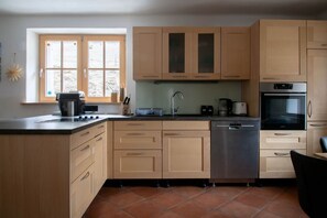 Una cocina con ventana, lavavajillas, estufa y armarios.