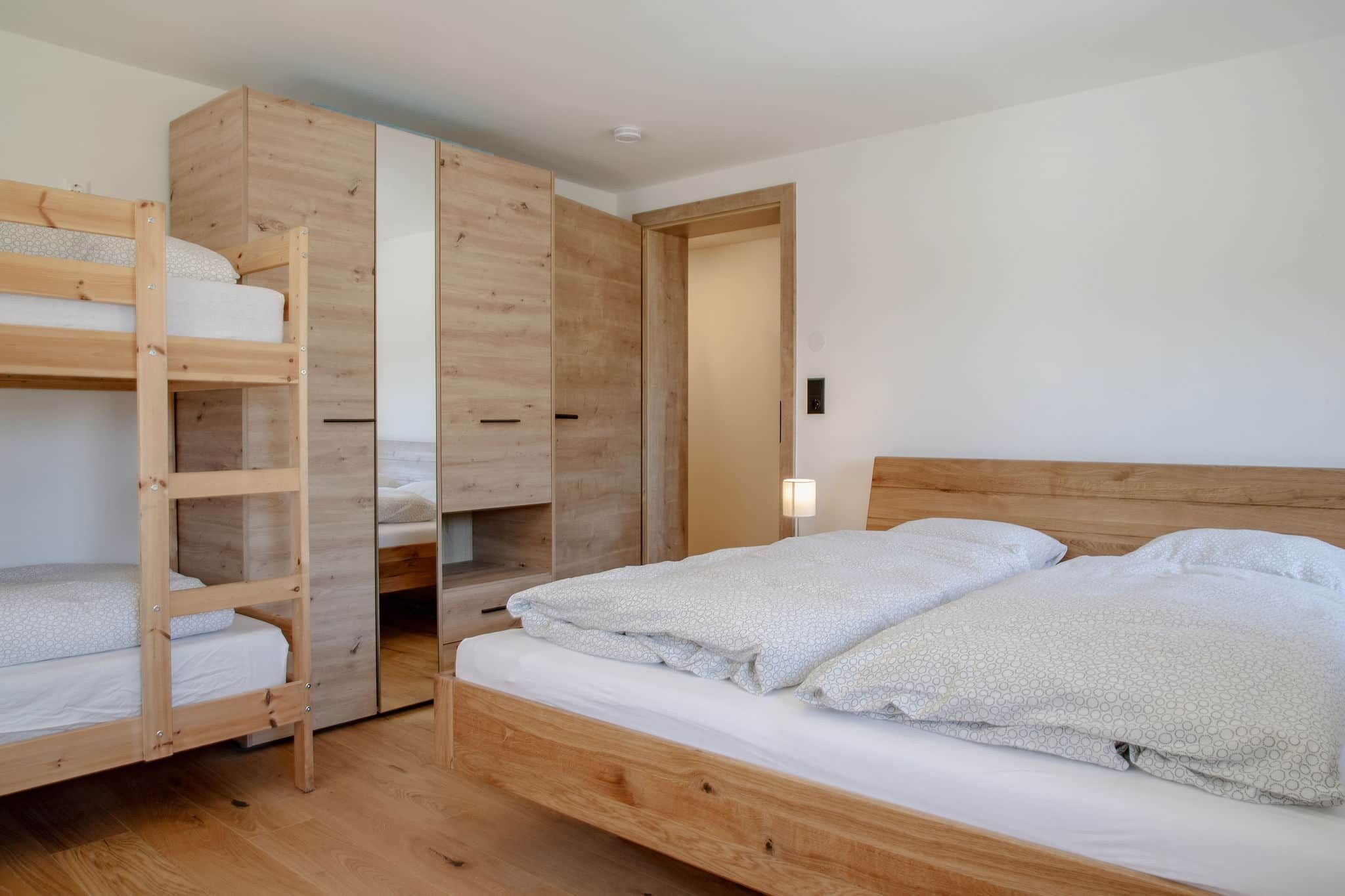 Ein Zimmer mit einem Etagenbett, einem Holzschrank und einem Nachttisch mit Lampe.