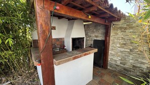 Una cocina con salpicadero de piedra, vigas de madera y un lavamanos empotrado.