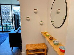 A modern interior with a wooden bench, a mirror, and wall-mounted planters. - Waikiki Banyan Pineapple Suite with AC & Free Parking (Honolulu)