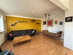 A living room with a sofa, a coffee table, a cat tree, and a lamp. - Fantastic 1 bedroom apartment in downtown Reykjavík (Reykjavík)