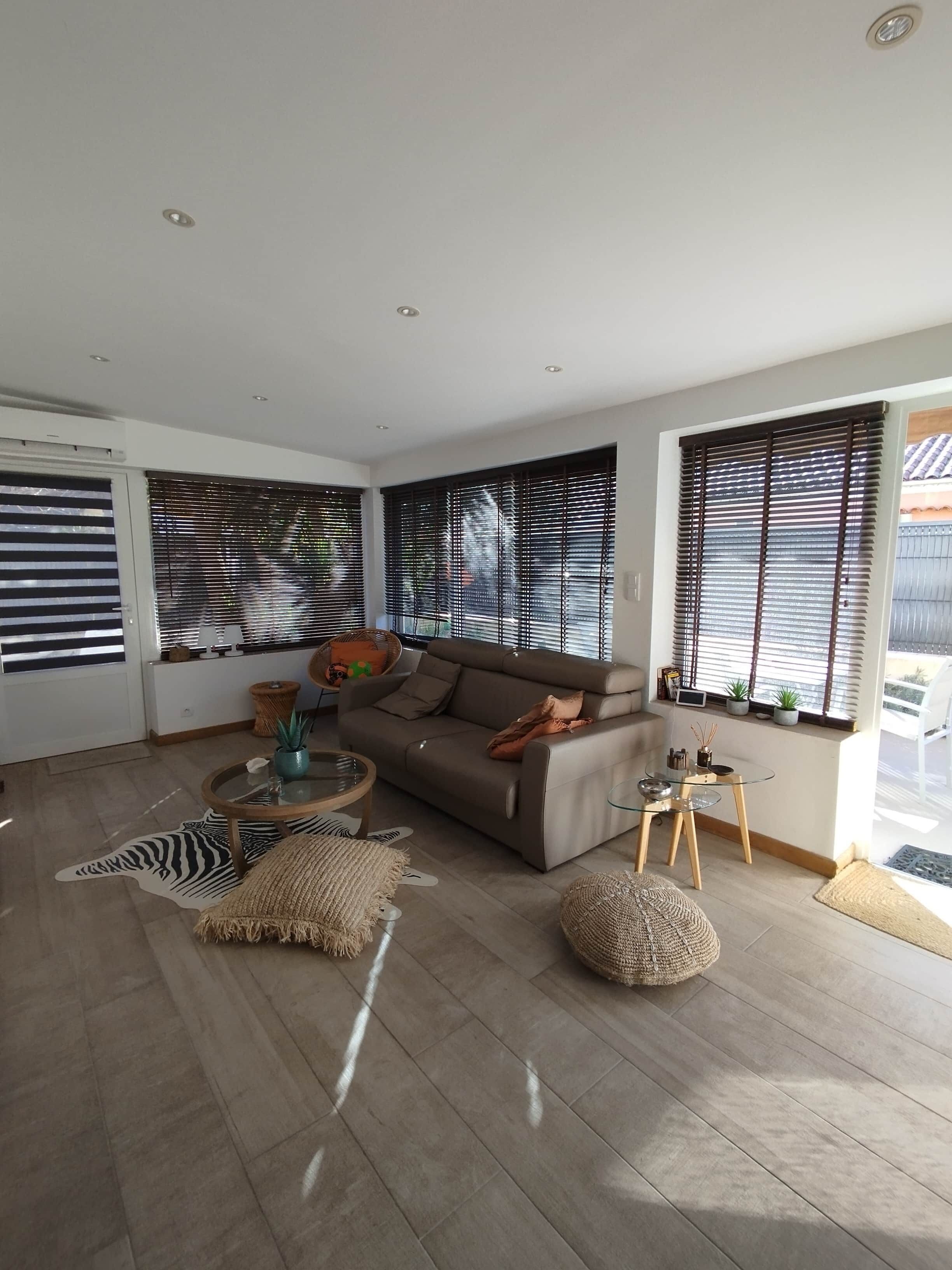 A modern living room with a sofa, a glass coffee table, and a zebra-patterned rug.