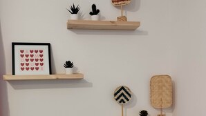 Due mensole di legno con oggetti decorativi e un quadro incorniciato su una parete.
