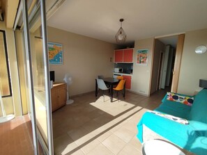 A compact living space with a kitchenette, dining area, and a sofa. - Exceptional sea view! Terrace, Private garage, Walking distance to the beach (Le Lavandou)