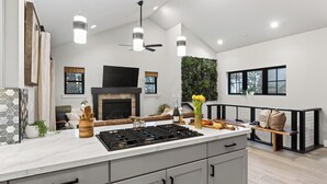 A modern kitchen with a central island, built-in appliances, and a seating area with a fireplace. - Tahoe Glen by Avantstay Steps to Lake + Near Cave Rock + Heavenly Ski Resort Tahoe Rim Trail (Glenbrook)