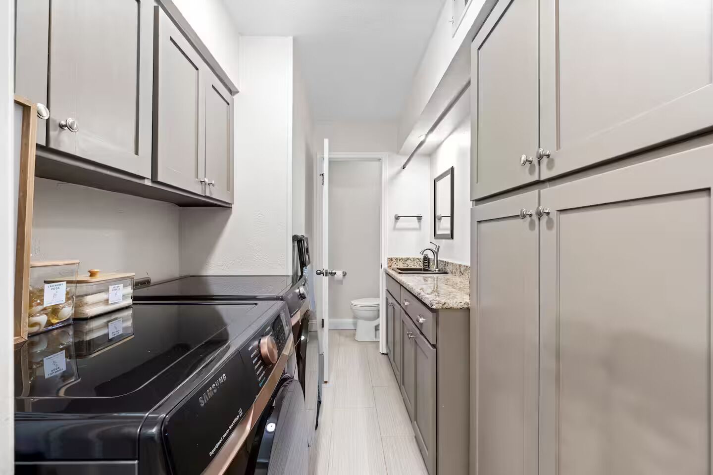 A narrow kitchen with a black Samsung oven, a sink, and cabinets.