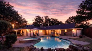 A residential property with a swimming pool, outdoor seating, and a covered patio area. - Dallas Pool House - Hot Tub & Game Room - Near DFW, Stadium (Irving)