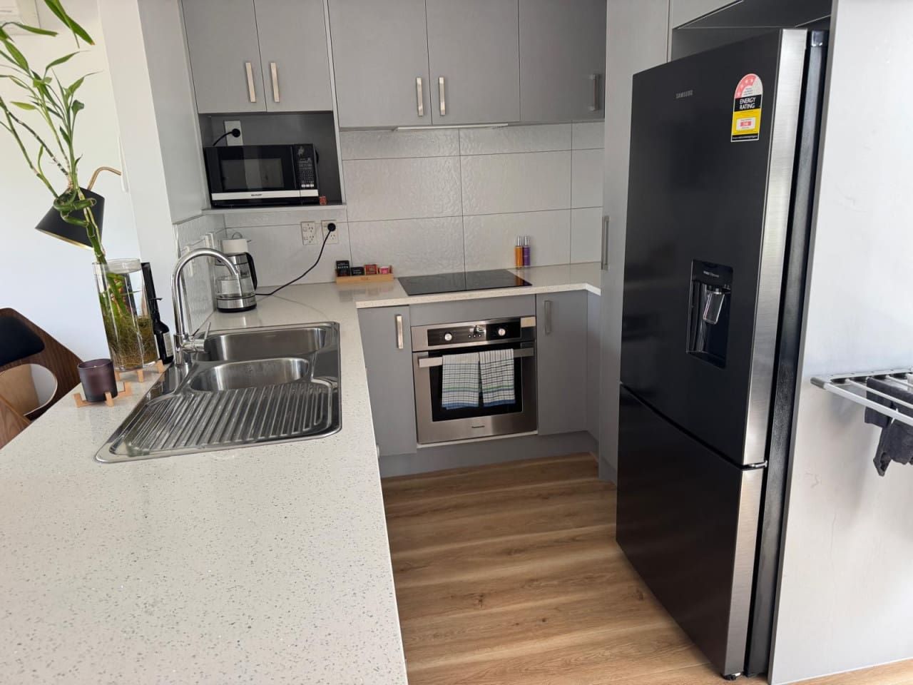 A kitchen with a stainless steel refrigerator, a microwave, and an oven built into the cabinetry.