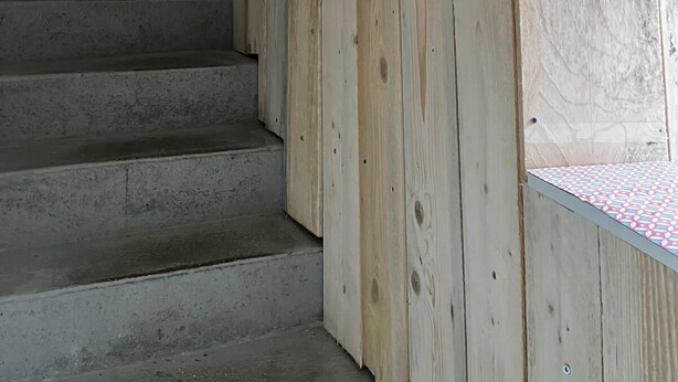 A wooden staircase with a red door at the top. - Charming apartment - historic heart of Aubusson (Aubusson)