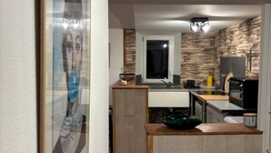 A modern kitchen with wooden cabinetry, a microwave, and a sink. - Charming apartment - historic heart of Aubusson (Aubusson)