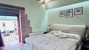 Une chambre à coucher avec un lit, un tapis à motifs, un plafond en bois et un mur orné de citations inspirantes encadrées.