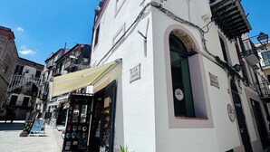Un immeuble à la façade blanche, doté d’un petit balcon et d’une enseigne indiquant « VIA DANTE ».