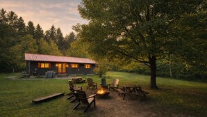 A rustic cabin with a fire pit and outdoor seating.