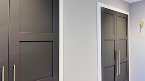 A set of dark-colored wardrobe doors with white trim and gold handles. - Cozy Edinburgh Escape (Edinburgh)