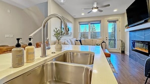 A modern kitchen with a large island, stainless steel sinks, and a built-in fireplace. - Perfect NEW family-friendly townhouse close to Winter Park!  Great views! (Fraser)