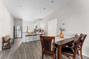 A modern kitchen with a refrigerator, microwave, and dining area with wooden chairs and a table. - Pool Steps Away! Perfect for Families! Walk-in! (Branson)