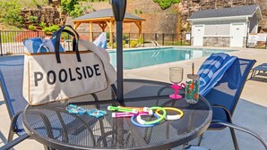 A poolside table with a bag labeled 'POOLSIDE,' a glass with a straw, and colorful hula hoops. - Pool Steps Away! Perfect for Families! Walk-in! (Branson)