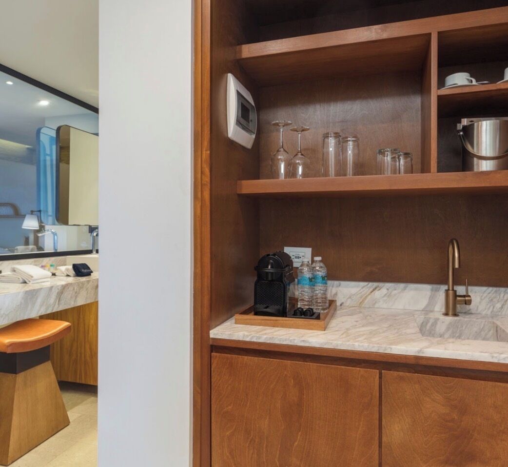 A modern bathroom with a wooden vanity, marble countertop, and a sink.