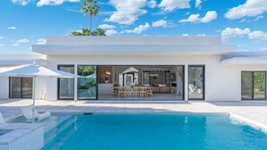 A modern house with a swimming pool, a patio with lounge chairs, and a dining area. - The Dreyfus | 5 Star Resort Style Designer Home (Scottsdale)