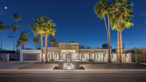 A modern building with a symmetrical facade, palm trees, and a clear sky. - The Dreyfus | 5 Star Resort Style Designer Home (Scottsdale)