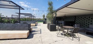 An outdoor patio area with seating, a pergola, string lights, and a covered section with patterned walls. - 129 Comfortable 1-bedroom Apartment (Johannesburg)