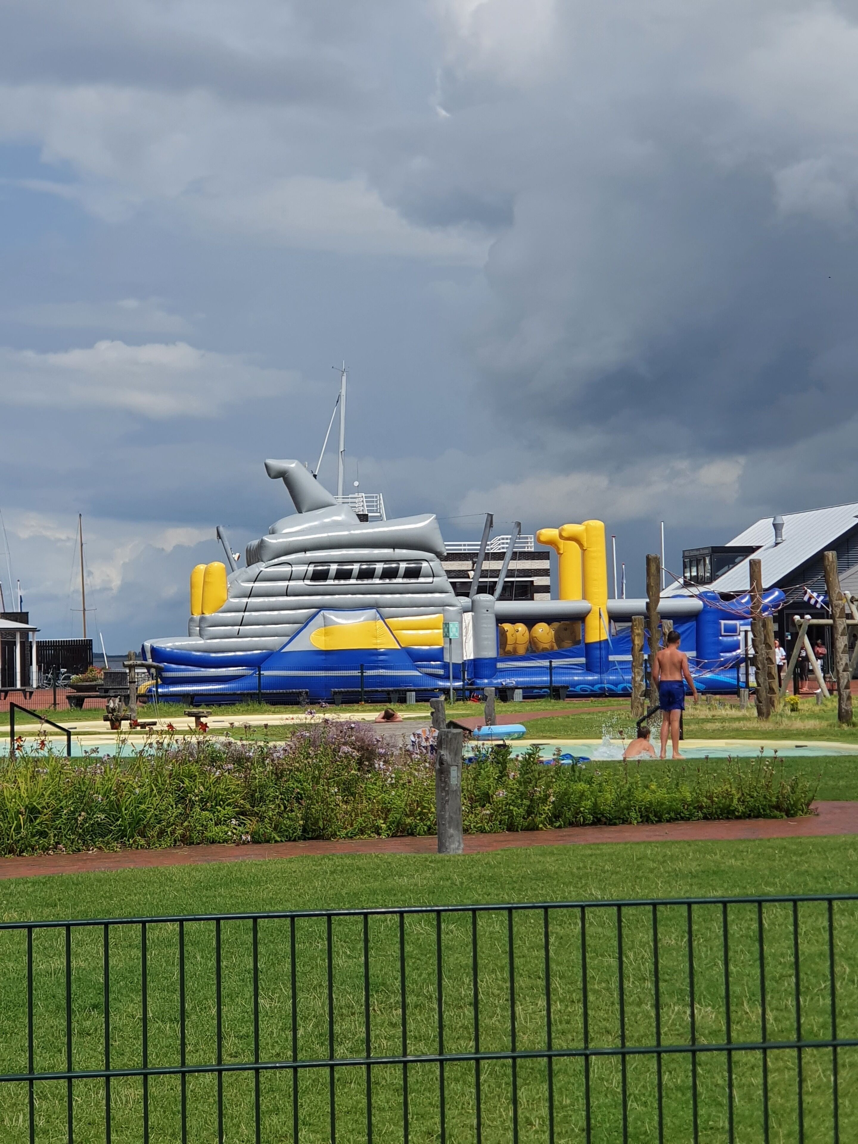 Una gran estructura inflable con forma de barco, rodeada de césped y una piscina.