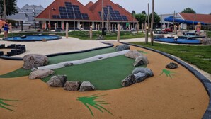 A playground with sand and rocks, solar panels on buildings, and a pool area. - Vacation home, Zeeland, Holland, North Sea, Starnd, WLAN, family-friendly park (Bruinisse)