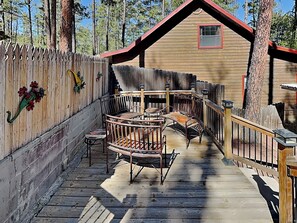 Eine Holzhütte mit Veranda, einem Holzzaun und einer Holzterrasse.
