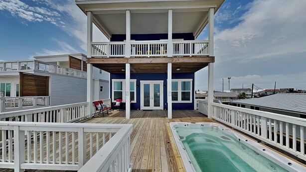 A two-story building with a balcony, a pool, and a deck. - Oceans Edge (Galveston)