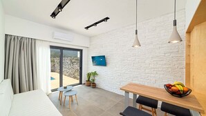 Et moderne køkken med spiseplads, et stort vindue og udsigt til det fri.