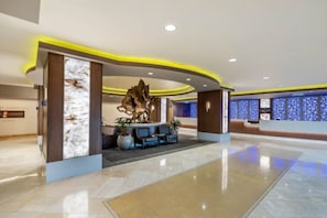 A modern lobby with a reception desk, seating area, and a large decorative sculpture. - F1 Weekend 2026 - 2BR on the Harmon Straight - 19th Floor - Sleeps 6 - Nov 18-22 (Las Vegas)