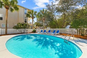 A swimming pool with lounge chairs, a white fence, and palm trees. - A Perfect Summer West (Walton County)