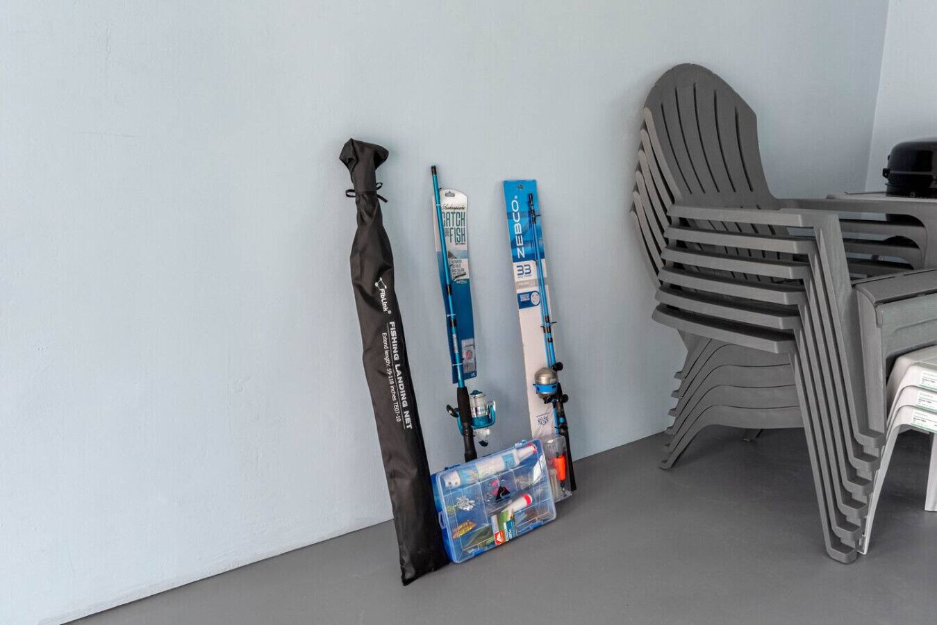 A room with a chair, a table, and skis leaning against a wall.