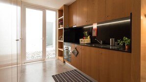 Et moderne køkken med træskabe, en sort bordplade og en indbygget ovn.