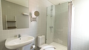 Een badkamer met een wastafel, toilet en douchecabine.