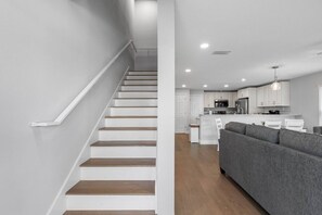 A modern interior with a staircase, a kitchen, and a living area. - Brand-New Waterfront Retreat Near Tampa Bay (Tampa)