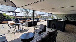 An outdoor patio with seating, a bar area, and a view of the cityscape. - 15 Sunny 1-bedroom Apartment (Johannesburg)