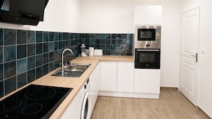 A modern kitchen with a built-in stove, microwave, oven, and washing machine. - ⭐ 70m² with Terrace - Near Paris, CDG & RER B (5min) (Sevran)