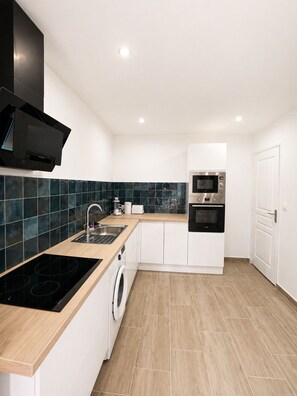 A modern kitchen with a built-in stove, microwave, oven, and washing machine. - ⭐ 70m² with Terrace - Near Paris, CDG & RER B (5min) (Sevran)