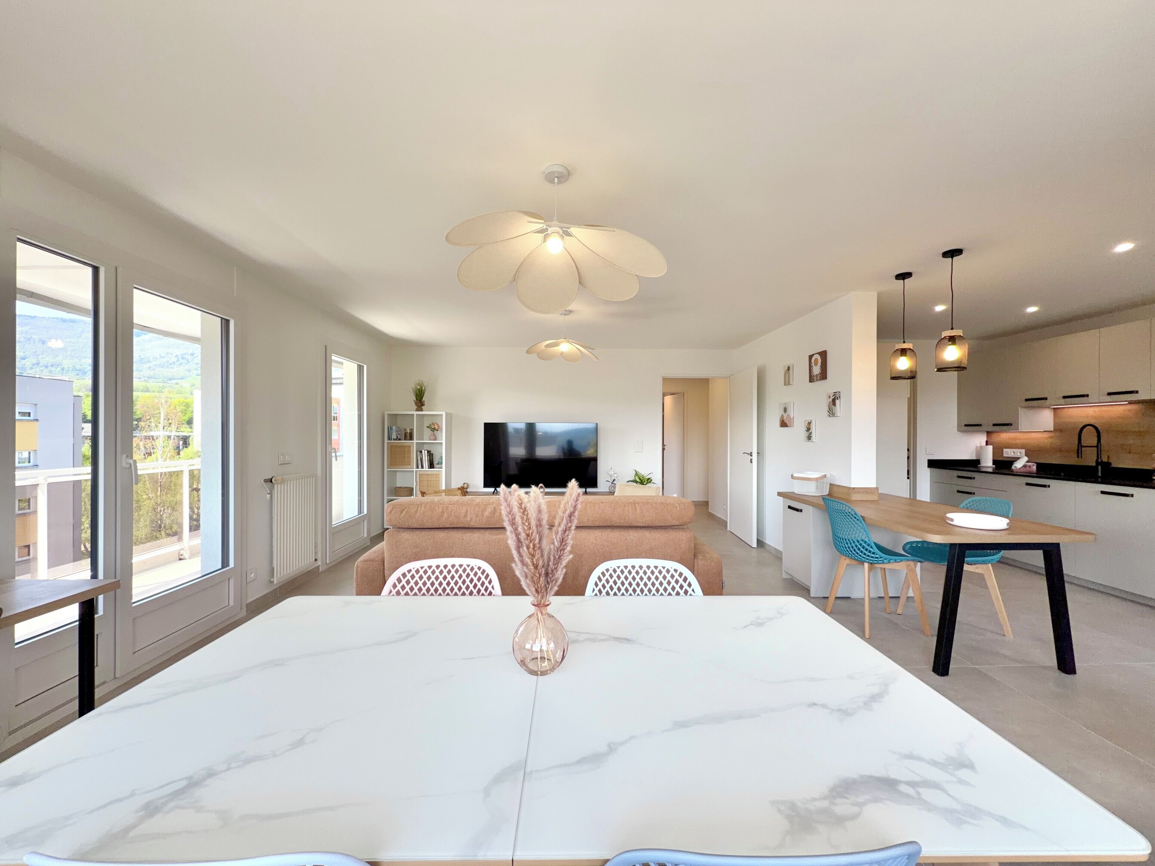Un appartement moderne comprenant un coin repas, une cuisine et un espace de vie.