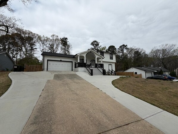 A two-story house with a front entrance, a driveway, and a garage.