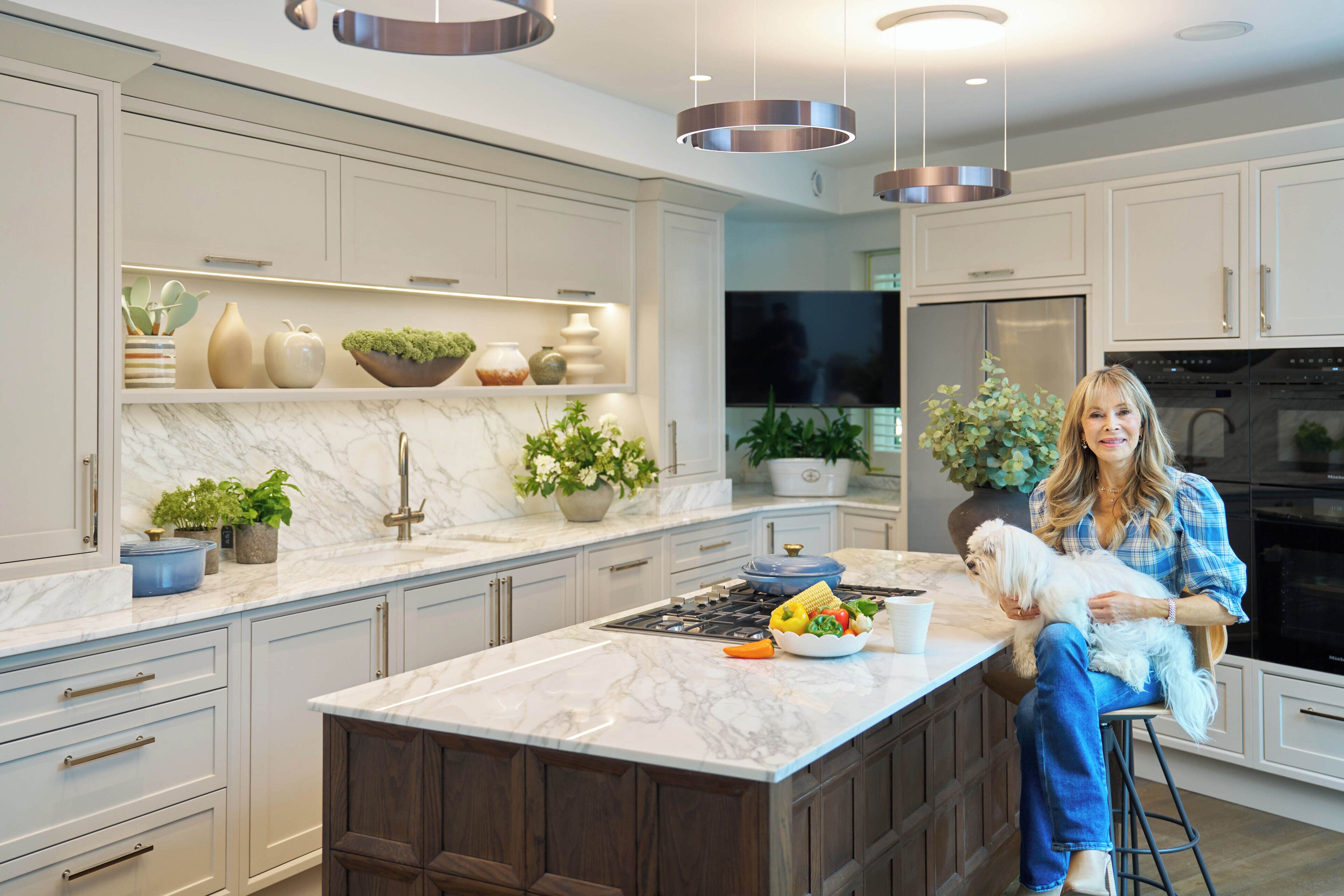A modern kitchen with marble countertops, stainless steel appliances, and a central island.
