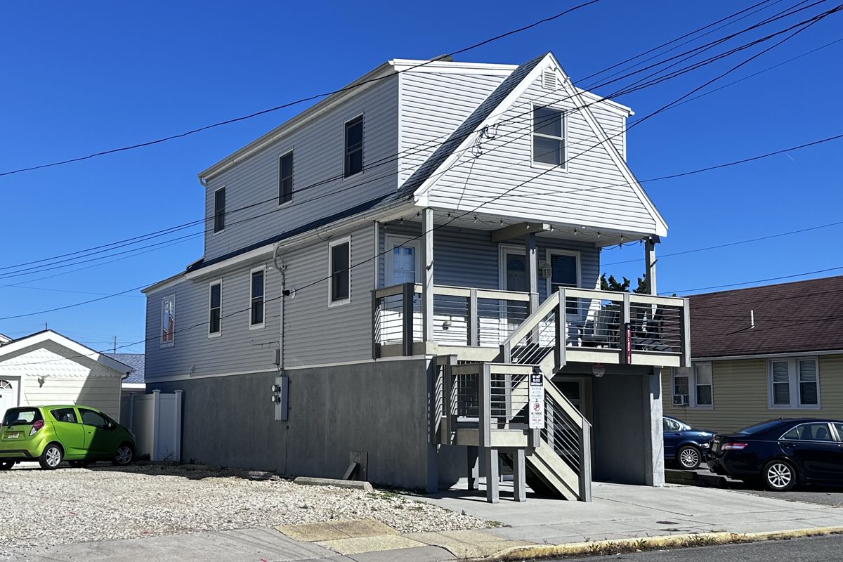 Un bâtiment à deux étages doté d’un balcon, d’un escalier et d’un garage.