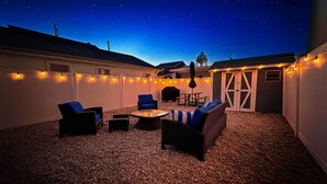 An outdoor patio area with seating, string lights, and a water feature. - 1BR Apt | High Speed WiFi | Washer/Dryer | Coffee (Seaside Heights)